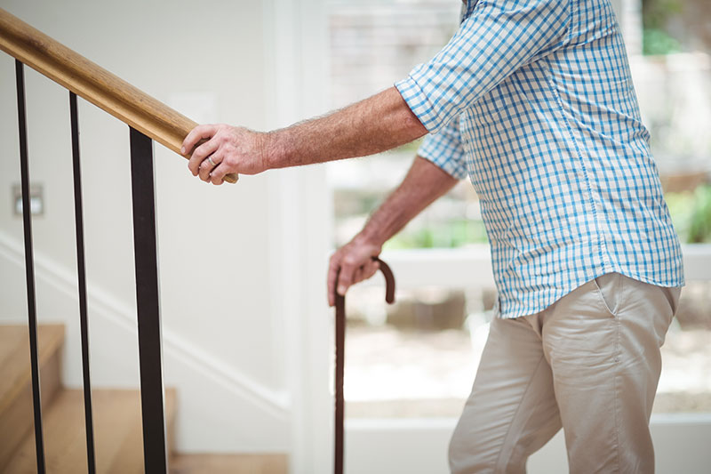 senior man with cane climbing stairs photo